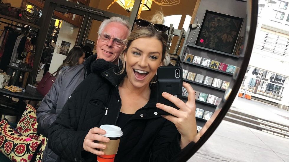 woman taking a picture with an older man in a mirror