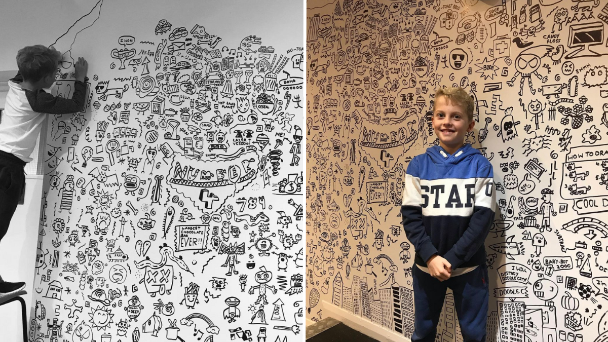 boy decorating a wall with doodles and standing in front of a wall with doodles