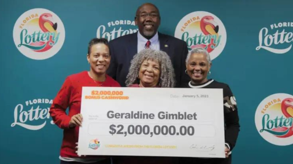 four people holding a big cheque
