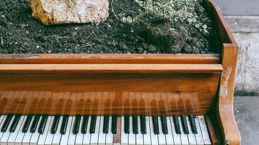 piano filled with dirt and rocks