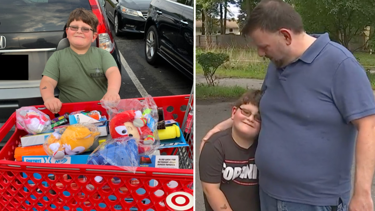 little boy standing with shopping cart filled with toys and a boy hugging his father