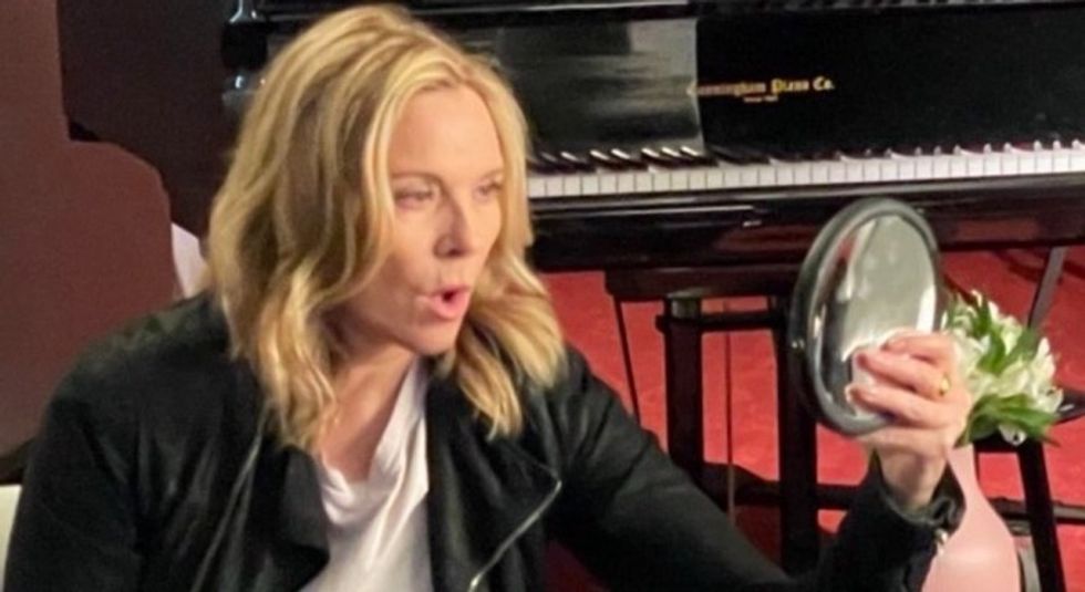 Kim Cattrall looking into a mirror and gasping.