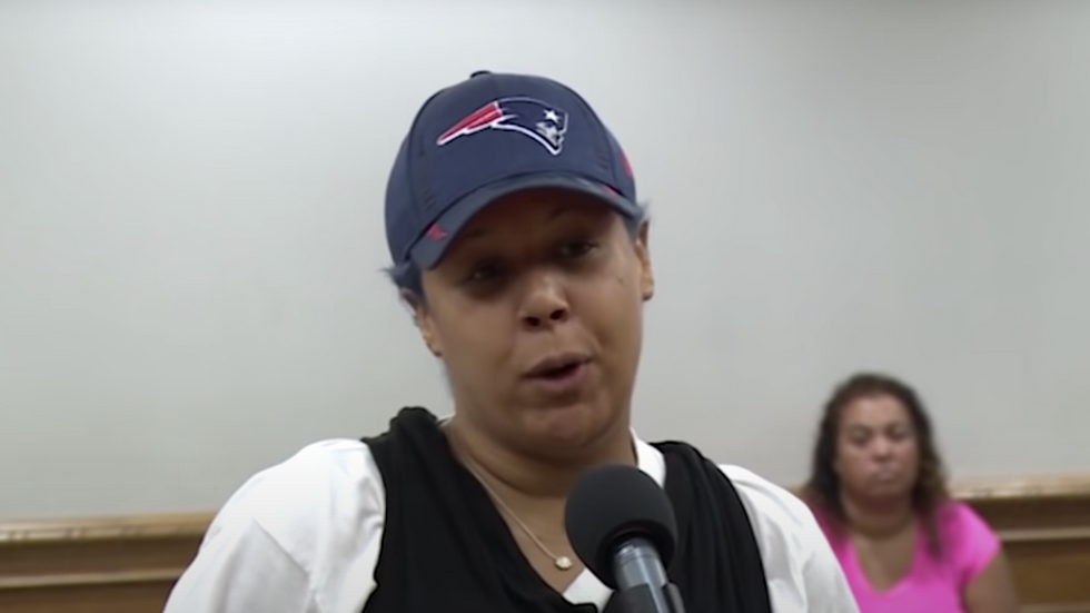 woman wearing a cap, speaking into a microphone
