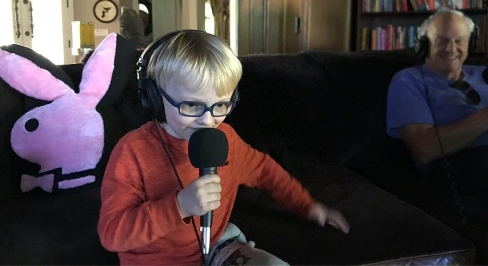 Chris Pratt's son, Jack Pratt, holding a microphone while sitting on the couch.