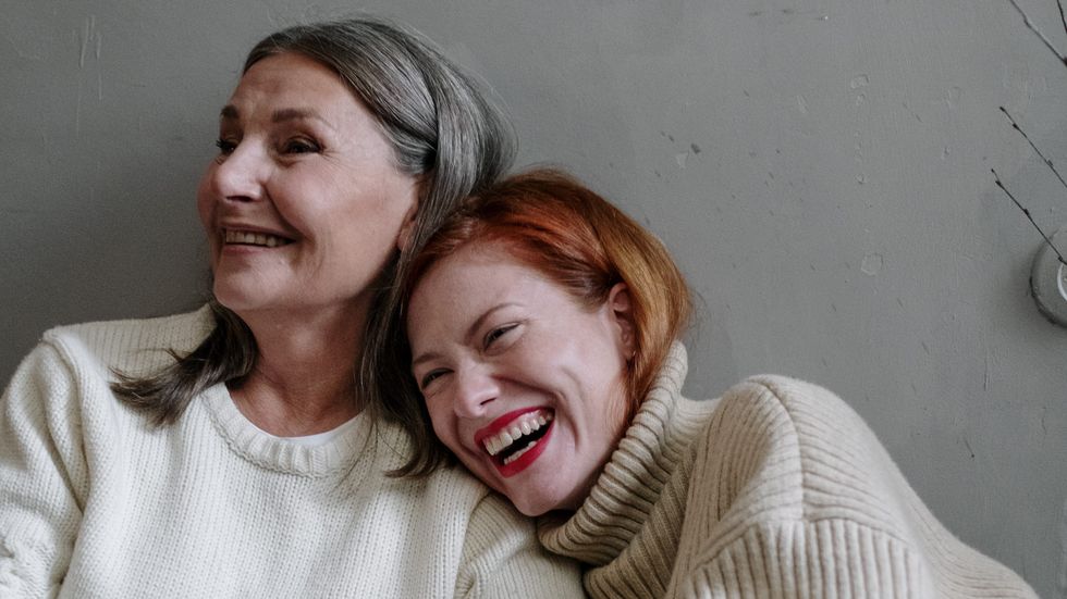 woman with red hair hugging a slightly older woman