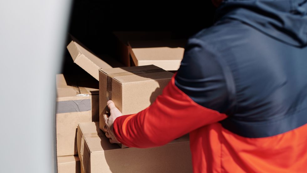 man holding unloading cardboard boxes