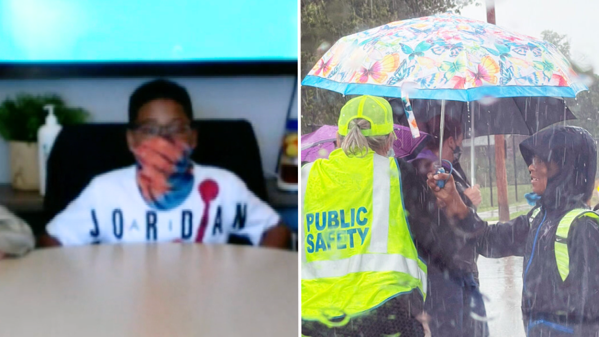 little boy wearing a mask and holding an umbrella for a crossing guard