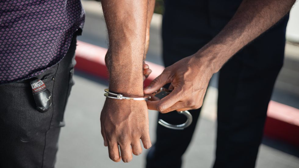 close up of a police officer hand cuffing a person