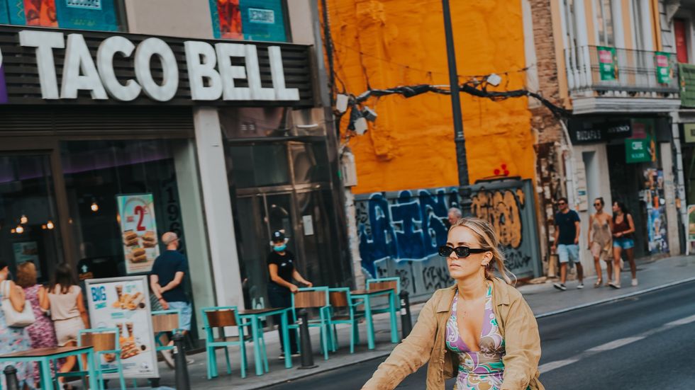 a woman wearing sunglasses outside Taco Bell restaurant