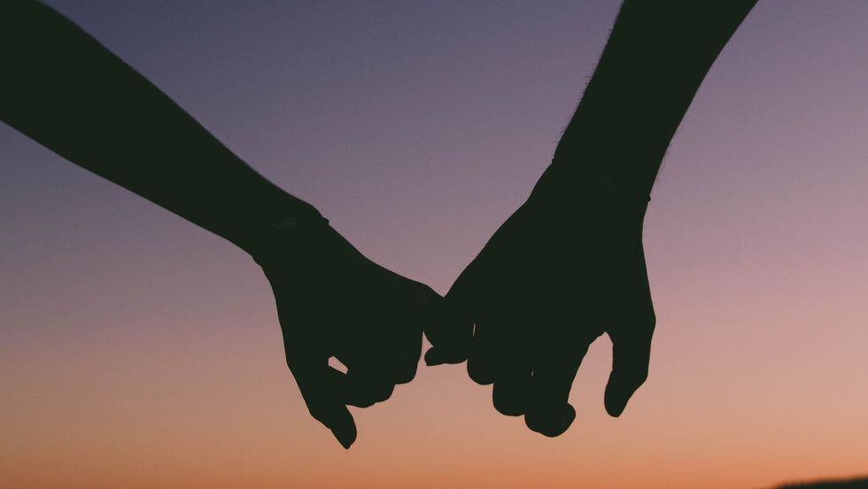 silhouette of two people holding hands