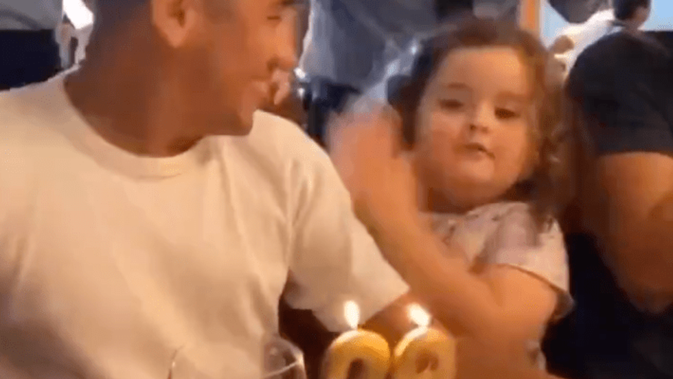 a little girl blowing candles on a birthday cake