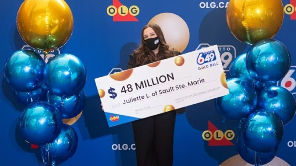woman holding a big cardboard cheque in her hands