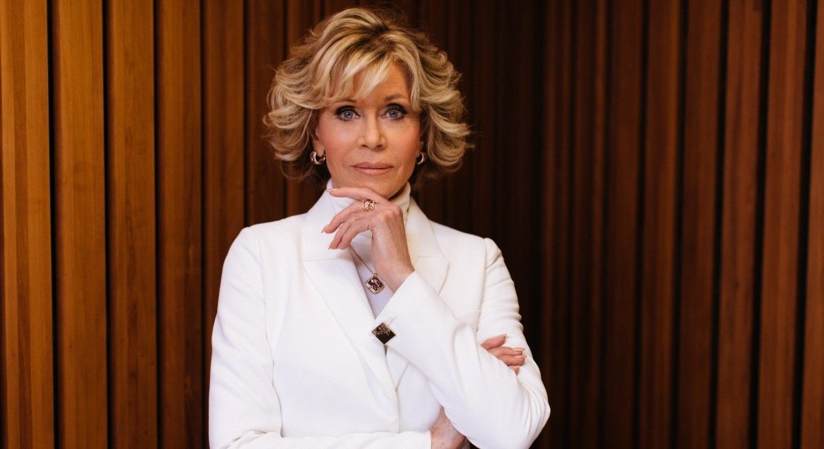 Jane Fonda wearing a white suit and looking ahead at the camera