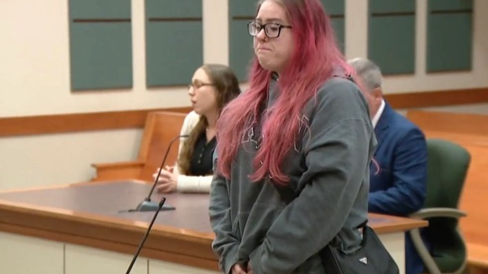 woman with pink hair in a courtroom