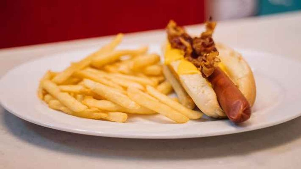 french fries and a hotdog on a white plate