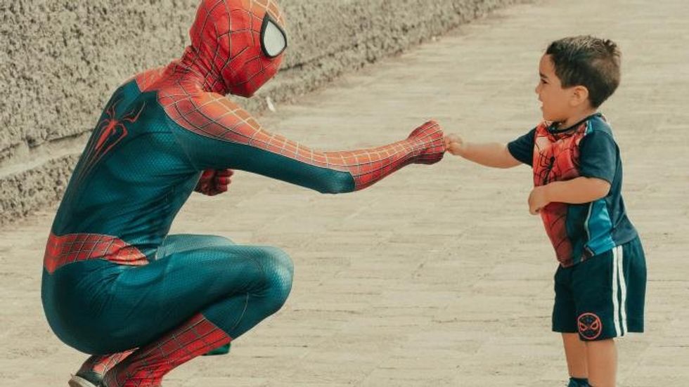 spiderman giving a little boy a fist bump