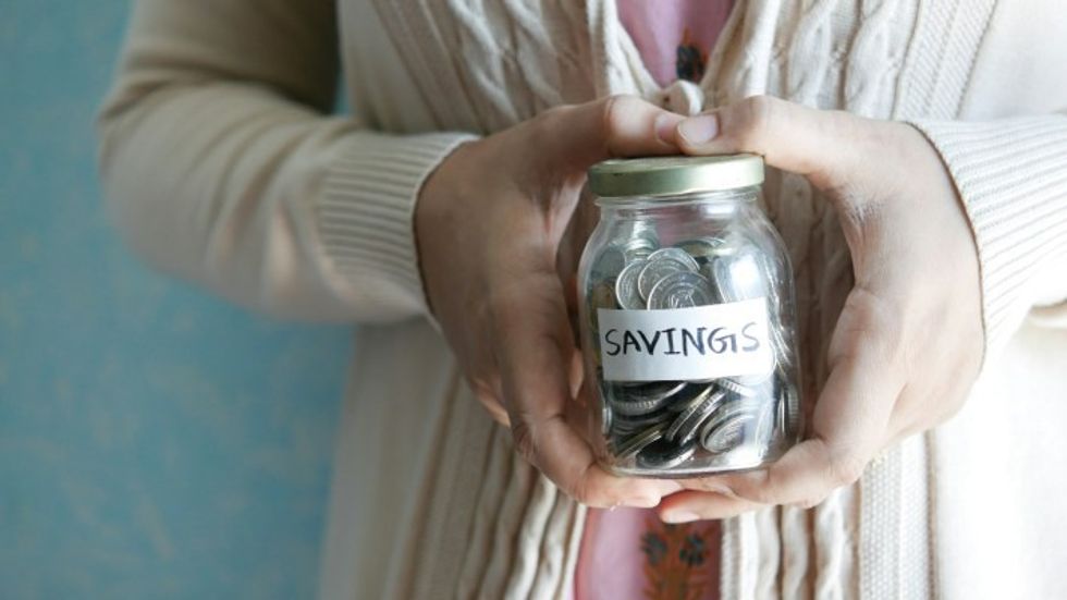 person holding a jar filled with coins